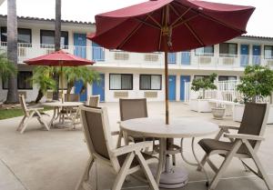 a patio with tables and chairs with umbrellas at Motel 6-Camarillo, CA in Camarillo