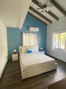 um quarto com uma cama branca numa parede azul em Blue Dream apartments em Simpson Bay