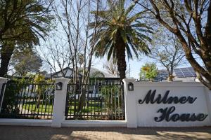 a white gate with a million house sign on it at Milner House Kimberley in Kimberley