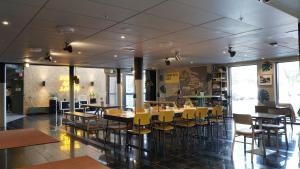 une salle à manger avec des tables et des chaises jaunes dans l'établissement Comfort Hotel Malmö, à Malmö