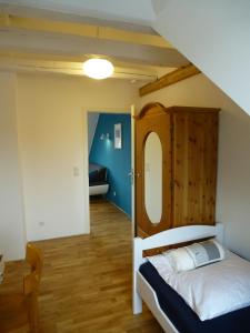 ラドルフツェル・アム・ボーデンゼーにあるFerienwohnung Casa Bluのベッドルーム1室(木製ヘッドボード付きのベッド1台付)