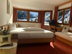 a hotel room with two beds and a television at Piz-Hotel in Sankt Leonhard im Pitztal