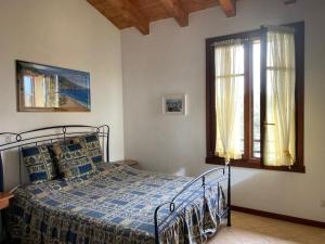 Schlafzimmer mit einem Bett und einem Fenster in der Unterkunft Comfortable apartment with view on swimming pool in Peschiera del Garda