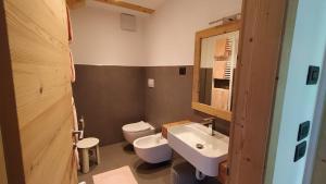 bagno con lavandino bianco e servizi igienici di Hotel Villa Rosa a Campitello di Fassa