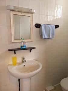 a bathroom with a sink and a mirror and a toilet at Altavia Hotel in Sandown