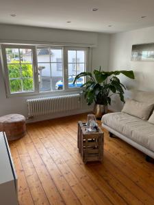 ein Wohnzimmer mit einem Sofa und einem Tisch in der Unterkunft Kleines, gemütliches Haus in Bonn in Bonn