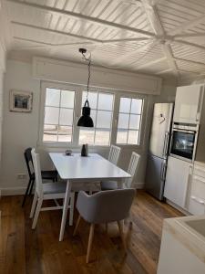 a kitchen and dining room with a white table and chairs at Kleines, gemütliches Haus in Bonn in Bonn