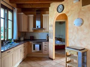 a kitchen with a sink and a clock on the wall at Well-kept apartment with view of the swimming pool in Peschiera del Garda