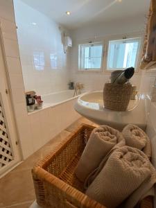 uma casa de banho com um lavatório e uma cesta de toalhas em Das Almsternderl - gemütliche Wohnung in Gosau em Gosau