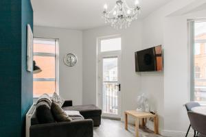 a living room with a couch and a chandelier at Mountain View Apartments in Newcastle