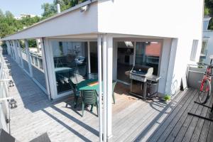 un porche cubierto con mesa y parrilla en Dachgeschoss Designer-Loft Arlberg - Montafon, en Bludenz