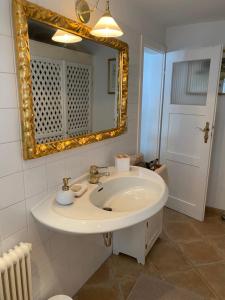 uma casa de banho com um lavatório branco e um espelho. em Das Almsternderl - gemütliche Wohnung in Gosau em Gosau