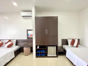 a room with two beds and a cabinet in it at Thăng Long Hotel in Con Dao