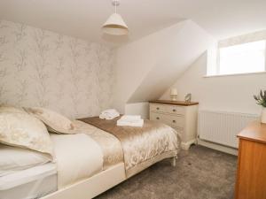 a bedroom with a bed and a dresser and a window at 1 The Riverside in Barnard Castle