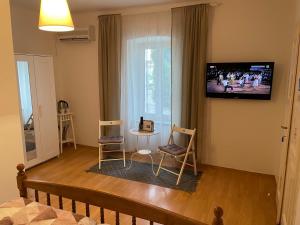 a living room with two chairs and a tv on the wall at Nine Sveti Juraj in Sveti Juraj