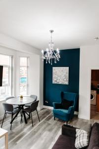 salon ze stołem i niebieską ścianą w obiekcie Mountain View Apartments w mieście Newcastle