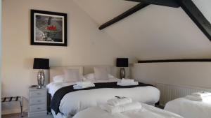 a bedroom with two beds with white sheets at Dragon Inn in Crickhowell