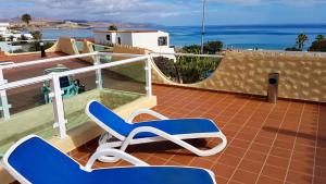 a blue and white chair sitting on a balcony at Ferienwohnung PLAYA - Pool - 50 m Strand - Meerblick - WiFi in Costa Calma