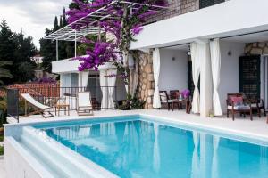 a swimming pool in front of a house at Apartments Villa Mirjana in Mlini