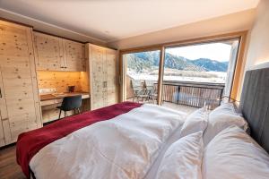 a bedroom with a large bed with a large window at Silent Luxury Chalet LAIET in San Valentino alla Muta