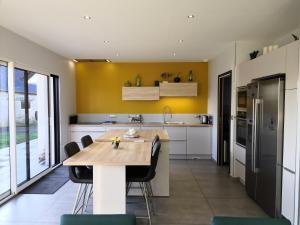 a kitchen with a wooden table and chairs at La Villa le 29 in Tracy-sur-Mer