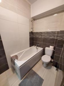 a bathroom with a bath tub and a toilet at Morii Lake Apartment in Bucharest +29 photos