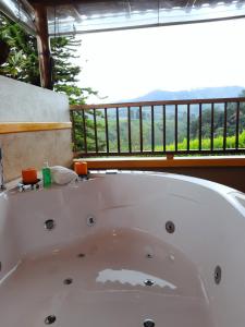 a white bath tub in a bathroom with a balcony at FINCA HOTEL DON JULIO in Santa Rosa de Cabal