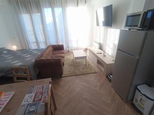 a small room with a bed and a couch and a television at Apartamento de lujo en la Sierra in Becerril de la Sierra