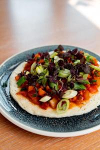 a pizza on a blue plate on a table at Townhouse Dresden in Dresden