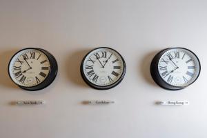 three clocks on a wall with different time zones at The Ellison in Castlebar