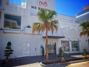 a palm tree in front of a building at MB Boutique Hotel - Adults Recommended in Nerja