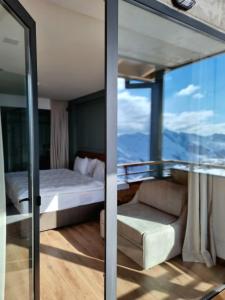 Habitación con cama, sofá y ventana en Monte Hotel, en Gudauri