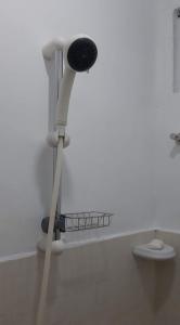 eine Dusche in einem weißen Zimmer mit Waschbecken in der Unterkunft Casa Erelle -1 Bedroom guest house #2 in Antipolo
