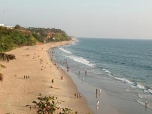 a group of people on a beach near the ocean at isha homestay in Varkala