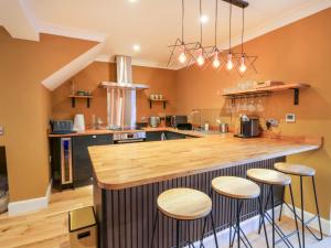 a kitchen with a counter and stools at a bar at Feus Holiday Cottage in Auchterarder