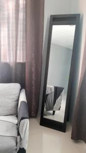 ein Spiegel neben einer Couch in einem Zimmer in der Unterkunft Casa Erelle -1 Bedroom guest house #2 in Antipolo