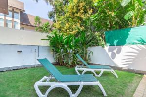 two lounge chairs and a pool in a yard at Luxury Villa Goa in Candolim