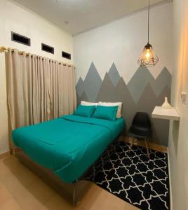 1 dormitorio con cama verde y alfombra negra en Kalih Homestay, en Pagaralam