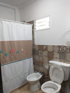 a bathroom with a toilet and a shower curtain at El Remanso in San Lorenzo