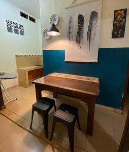 una mesa y dos taburetes en una habitación en Kalih Homestay, en Pagaralam