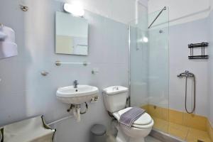 a bathroom with a toilet and a sink and a shower at Roberto's Apartments in Roda +9 photos