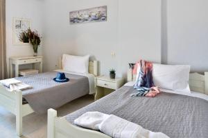a bedroom with two beds and a table at Roberto's Apartments in Roda