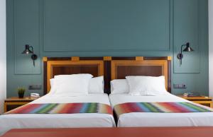 dos camas sentadas una al lado de la otra en una habitación en Hotel Don Curro, en Málaga
