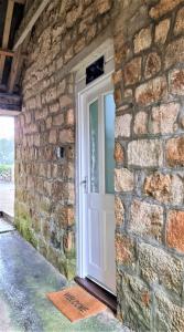 un mur en briques avec une porte blanche dans un bâtiment en pierre dans l'établissement Tregenna Castle Resort, à St Ives