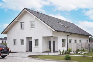 biały dom z czarnym dachem w obiekcie Zielona Dolina 2020 w mieście Smolice