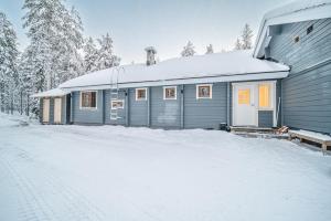 a blue house with snow on the ground at Levillas Lammaskuru in Levi