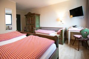 a hotel room with two beds and a table and a sink at Landhotel-Restaurant Beckmann in Heiden