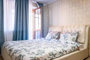 1 dormitorio con 1 cama con cortinas azules y ventana en StudioMinsk 4 Apartments - Minsk, en Minsk