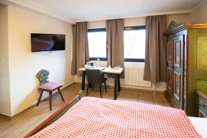 a bedroom with a bed and a table and a desk at Landhotel-Restaurant Beckmann in Heiden +40 photos