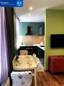 a kitchen with a table and chairs and a television at Green and quiet city center in Rīga